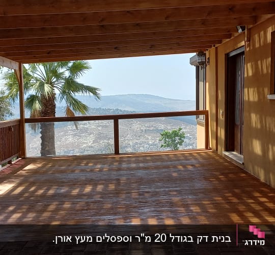 מרפסת עץ עם עצים וצינור מים